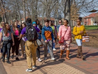 A tour guide talks with his group