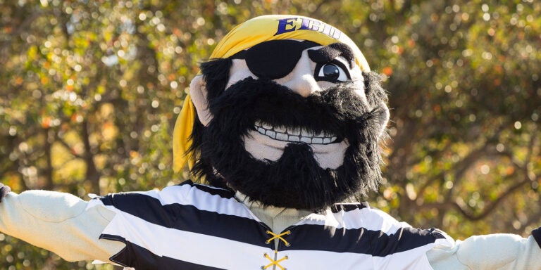 ECU mascot PeeDee the Pirate faces the camera with his arms stretched out as if showing off campus.